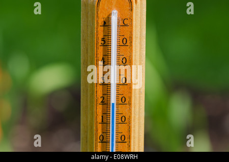 hölzerne Außenthermometer zeigt 20 Grad Celsius auf Natur Hintergrund Stockfoto