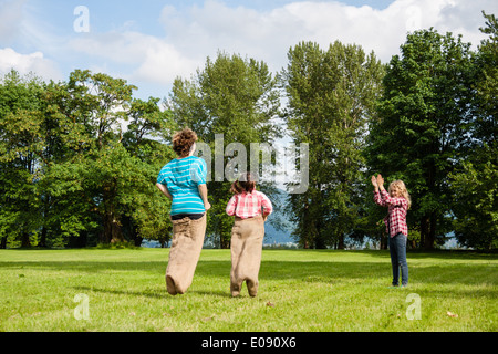 Mädchen in einem Sackleinen Sackhüpfen Stockfoto