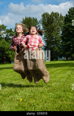 Mädchen in einem Sackleinen Sackhüpfen Stockfoto