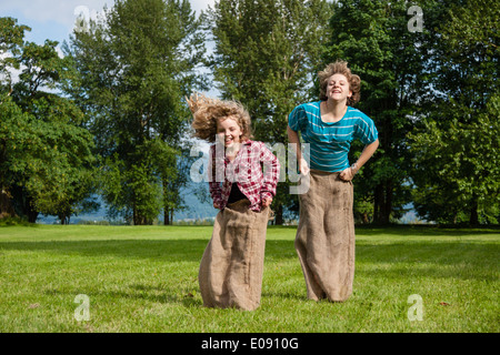 Mädchen in einem Sackleinen Sackhüpfen Stockfoto