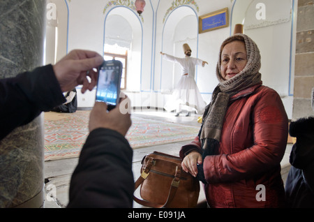 Touristen fotografieren mit Wachsfigur von tanzender Derwisch auf Hintergrund. Mevlana Jalaluddin Rumi Museum in Konya, Türkei Stockfoto