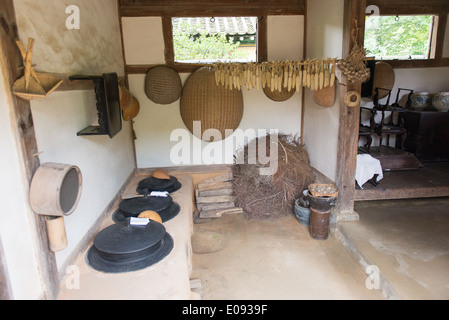 In einem traditionellen koreanischen Haus mit Kachelofen und landwirtschaftliche Werkzeuge eine korean folk Village Stockfoto
