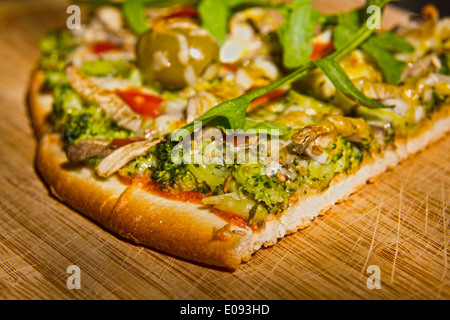 Hausgemachte vegetarische Pizza auf einer hölzernen Platte. Stockfoto