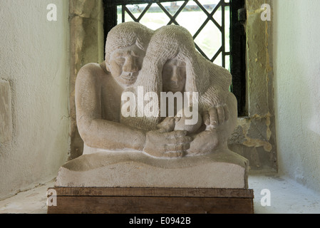 Geschnitzte Figuren, welche die Familie in die Kirche von St. Michael und alle Engel, Berwick, East Sussex, UK. Stockfoto