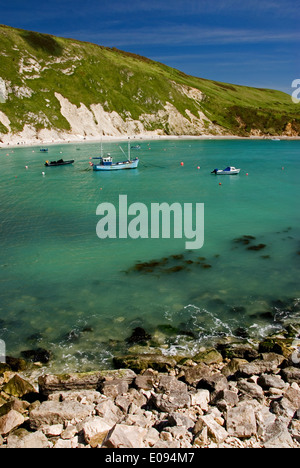 Boote in den abgelegenen Hufeisen geformte Bucht bei Lulworth, an der Jurassic Coast in Dorset, England. Stockfoto