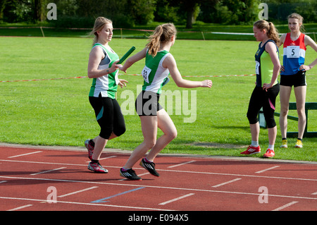 Leichtathletik, Läufer vorbei Baton in Frauen 4X400m Staffelrennen auf Vereinsebene, UK Stockfoto