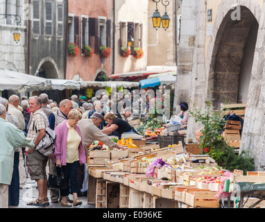 Lebensstil: Einheimische kaufen Produkte, Obst und Gemüse auf einem geschäftigen, blühenden, überfüllten Straßenmarkt in Annecy, Frankreich Stockfoto