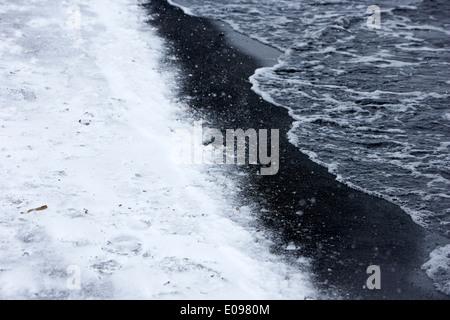 Schnee, der auf schwarzem Vulkansand in der Caldera Whalers Bucht Täuschung Insel Antarktis Stockfoto