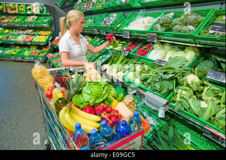 Eine junge Frau mit dem Kauf Vopn Obst und Gemüse im Supermarkt, Eine Junge Frau Beim Einkauf Vopn Obst Und Gemuese ich Stockfoto