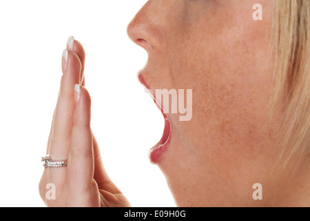 Eine junge Frau hält die Hand vor den Mund mit dem Gähnen. Müdigkeit und Schlaf Mangel, Eine Junge Frau Haelt Sich Beim Gaehne Stockfoto