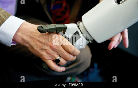 Berlin, Deutschland. 7. Mai 2014. Präsident der Humboldt-Universität Berlin, Jan-Hendrik Olbertz, schüttelt die Hand mit dem humanoiden Roboter "Myon", die am Institut für Informatik der Humboldt-Universität in Berlin, Deutschland, 7. Mai 2014 entwickelt wurde. Foto: CHRISTOPH SCHMIDT/Dpa/Alamy Live News Stockfoto