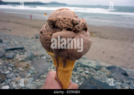 Schokoladen-Eiscreme-Kegel am Meer, Wales Stockfoto
