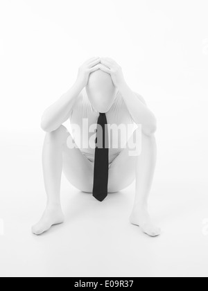 Unbekannte Person gekleidet in schwarze Krawatte und weißen Anzug mit den Händen auf dem Kopf sitzen verärgert auf weißem Hintergrund Stockfoto