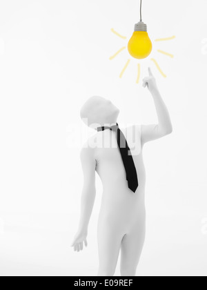 der Mann ohne Gesicht in weiß gekleidet mit schwarzer Krawatte mit gelben Glühbirne auf seinem Kopf Stockfoto