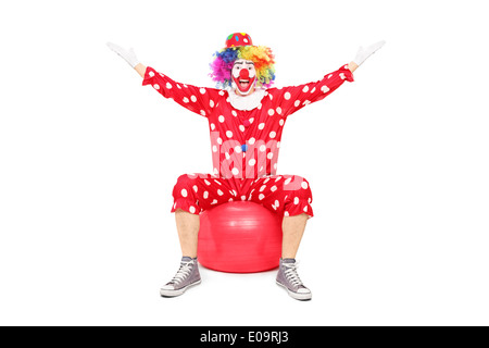 Überglücklich Clown sitzt auf einem Fitness-ball Stockfoto