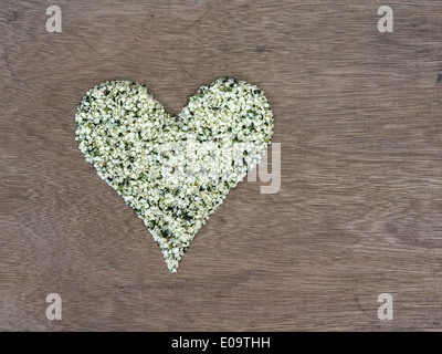 Bio geschälte Hanfsamen in einem herzförmigen symbol Stockfoto