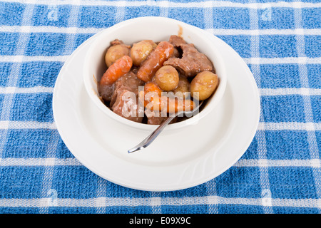 Ein herzhaftes Rindfleisch oder Lamm Eintopf in eine weiße Schale auf ein blaues Handtuch Stockfoto