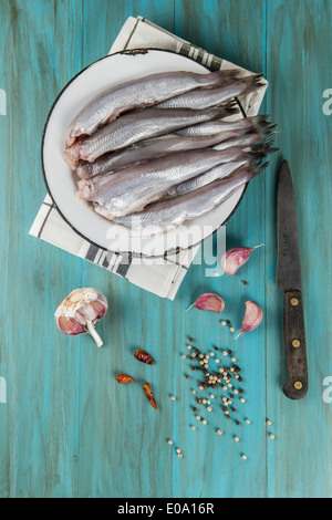 Eine Platte mit Fisch auf dem Küchentisch und Zutaten zu kochen. Stockfoto