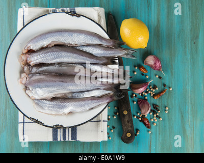 Eine Platte mit Fisch auf dem Küchentisch und Zutaten zu kochen. Stockfoto