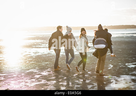 Fünf Erwachsene Freunde, spazieren am Strand Stockfoto