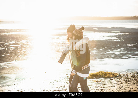 Zwei junge Erwachsene Freundinnen spazieren am Strand Stockfoto