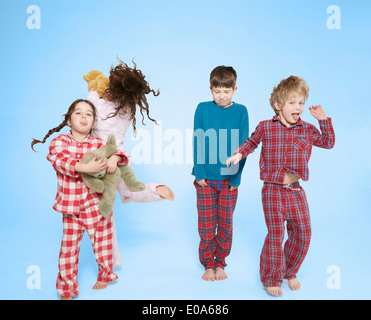 Kinder im Pyjama tanzen und springen Stockfoto