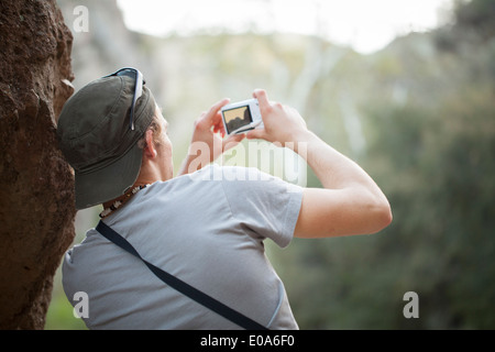 Junger Mann neben Rock nehmen Foto Digitalkamera Stockfoto