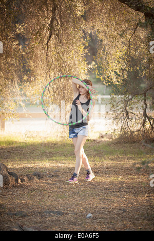 Junge Frau mit Hoola Hoop neben See durchführen Stockfoto