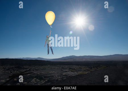 Mitte erwachsenen Mannes schwimmende mit Ballon in Wüste Stockfoto