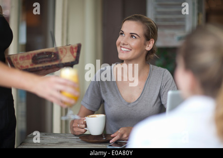 Zwei junge Erwachsene weibliche Freunde Menü im Café bestellen Stockfoto