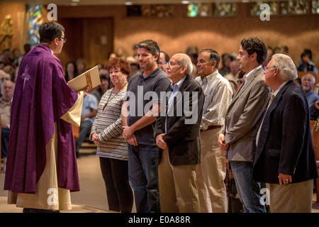 Katechumenen oder Menschen wollen Katholiken, werden zusammen mit ihren Sponsoren vor eine Robe vietnamesische amerikanische Priester für die Prüfung in einer katholischen Kirche in Laguna Niguel, CA. Stockfoto