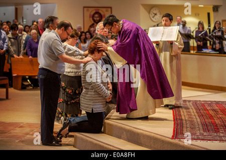 Katechumenen oder Menschen, die Katholiken, werden Knien mit ihren Sponsoren vor eine Robe vietnamesische amerikanische Priester für die Prüfung in einer katholischen Kirche in Laguna Niguel, CA. Stockfoto