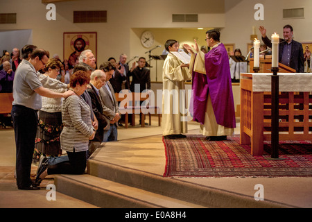 Katechumenen oder Menschen, die Katholiken, werden Knien mit ihren Sponsoren vor eine Robe vietnamesische amerikanische Priester für die Prüfung in einer katholischen Kirche in Laguna Niguel, CA. Stockfoto