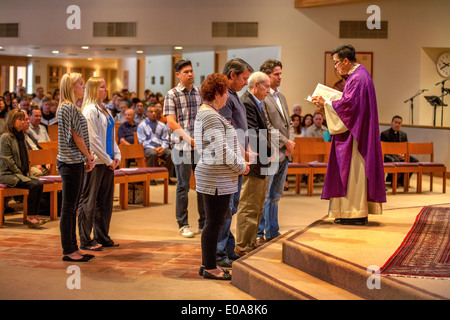 Katechumenen oder Menschen wollen Katholiken, werden zusammen mit ihren Sponsoren vor eine Robe vietnamesische amerikanische Priester für die Prüfung in einer katholischen Kirche in Laguna Niguel, CA. Stockfoto