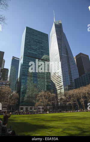 Blick nach Westen über Bryant Park mit der Bank Of America Tower droht bis in den Himmel entlang 6th Avenue an der 42nd Street in New York City. Stockfoto
