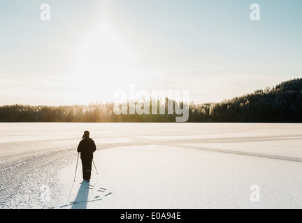 Reifer Mann nordic walking durch Schnee bedeckt Feld Stockfoto