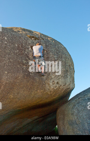 Junger Mann mit Seilen auf Felsen klettern Stockfoto