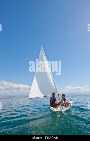 Zwei junge Männer, die auf das Meer hinaus Segeln Stockfoto