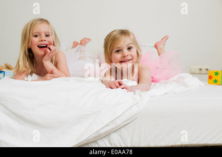 Porträt von zwei jungen Schwestern auf Bett liegend Stockfoto