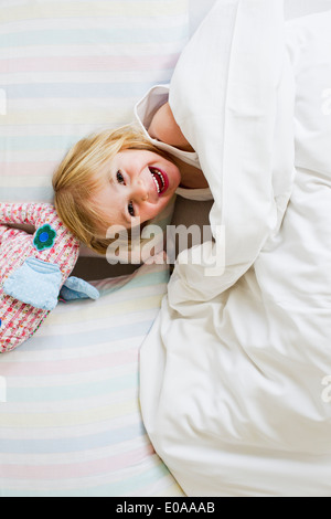 Porträt des jungen Mädchens liegen im Bett mit Spielzeug Elefant Stockfoto