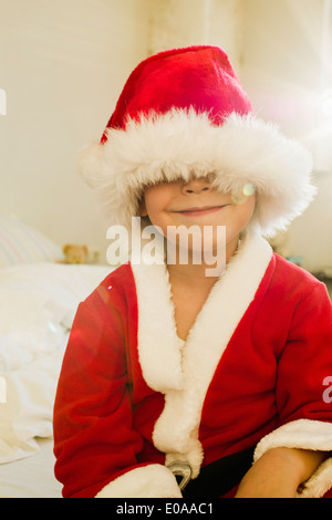 Porträt des jungen von Santa Outfit Kappe versteckt Stockfoto