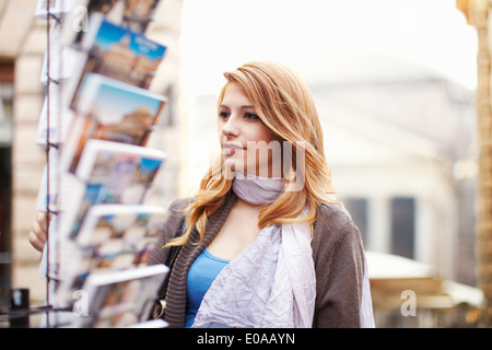 Junge Frau Blick auf Postkarten, Rom, Italien Stockfoto