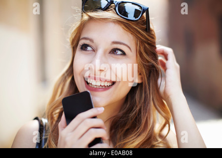 Anspruchsvolle junge Frau mit Smartphone nachschlagen Stockfoto