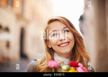 Lächelnde junge Frau mit einem Blumenstrauß Stockfoto