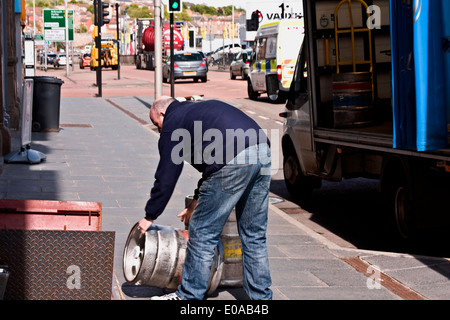 Arbeiter entladen einen Aluminium Keg von Guinness Stout Bier aus einem Lieferwagen vor einem schottischen Pub in Dundee, Großbritannien Stockfoto