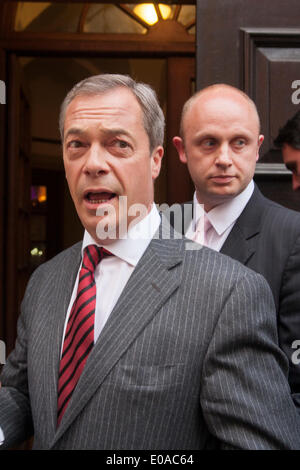 London, 7. Mai 2014. Der UKIP Nigel Farrage gelangt über einen Hintereingang wie Antirassismus Demonstranten außerhalb der Emmanuel Centre in Westminster zu demonstrieren, wie Ticketinhaber, vor seiner Ankunft an ihrer London-Kundgebung in die Warteschlange. Bildnachweis: Paul Davey/Alamy Live-Nachrichten Stockfoto