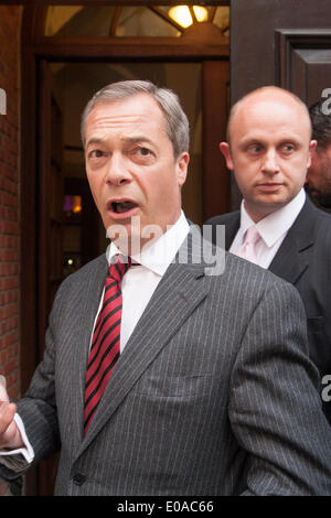 London, 7. Mai 2014. Der UKIP Nigel Farrage gelangt über einen Hintereingang wie Antirassismus Demonstranten außerhalb der Emmanuel Centre in Westminster zu demonstrieren, wie Ticketinhaber, vor seiner Ankunft an ihrer London-Kundgebung in die Warteschlange. Bildnachweis: Paul Davey/Alamy Live-Nachrichten Stockfoto