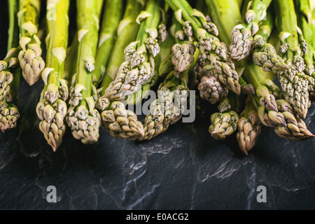 Junger Grüner Spargel auf schwarzem Glas. Stockfoto