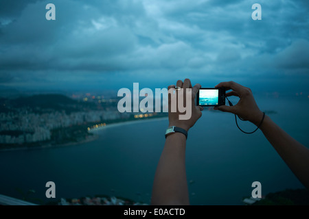 Nahaufnahme von weiblichen Händen fotografieren Aussicht auf Rio De Janeiro in der Nacht, Brasilien Stockfoto