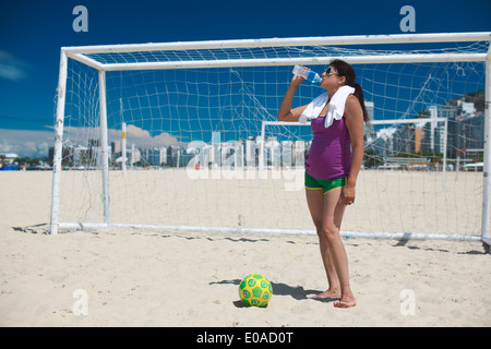 Reife Frau und Fußball Ball am Strand der Copacabana, Rio De Janeiro, Brasilien Stockfoto